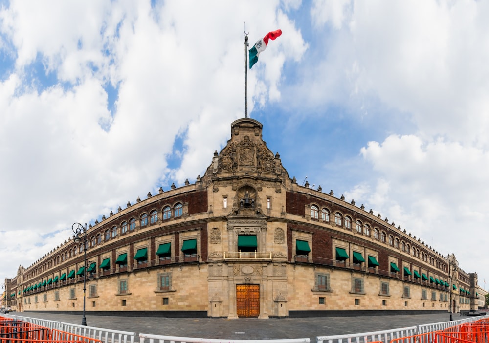 a large stone building with flags on top with National Palace in the background