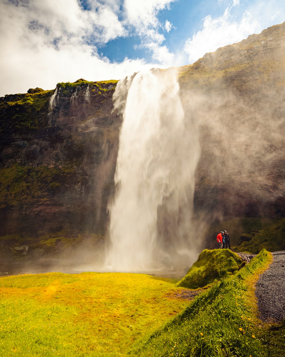 a person standing on a rock near a waterfall