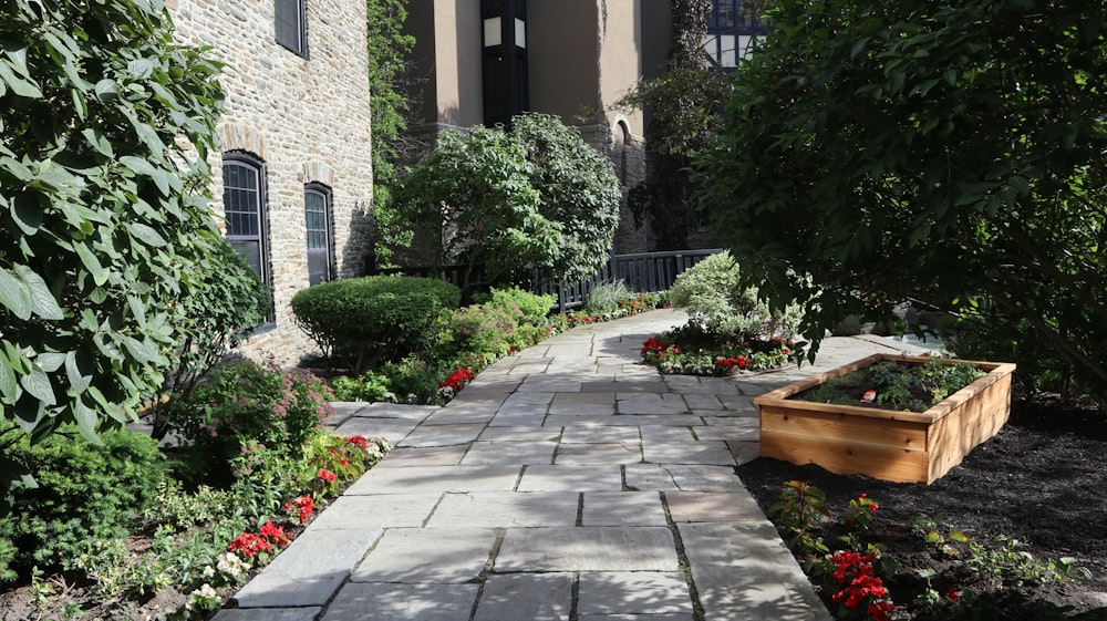 a brick walkway with plants and trees