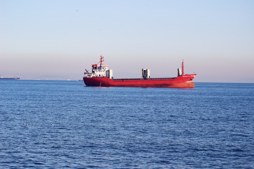 a red and white ship in the water