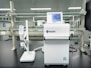 A laboratory setting featuring a water purification system with the brand name Rephile displayed on it. The setup includes a control unit with a digital display screen and an attached dispenser with a control panel. The background shows lab shelves and equipment, indicating a clean, sterile environment.