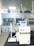 A laboratory setting featuring advanced equipment, including a white Rephile machine with digital controls and various attachments. In the background, there are large lab cabinets and ventilation hoods, with a bright, well-lit environment.