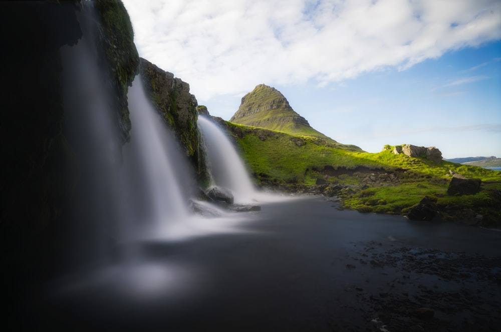 a waterfall with grass and rocks