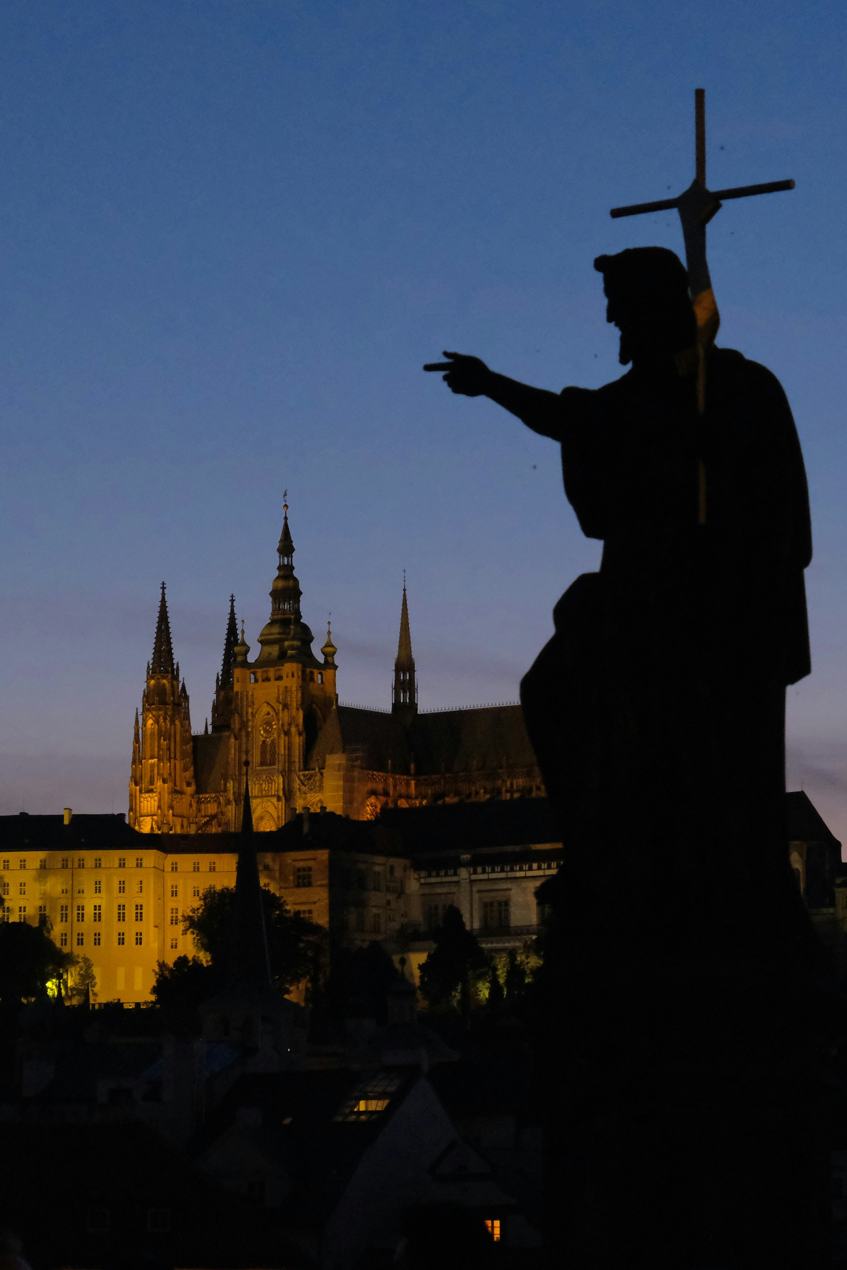 建物の前に十字架を持つ人の像