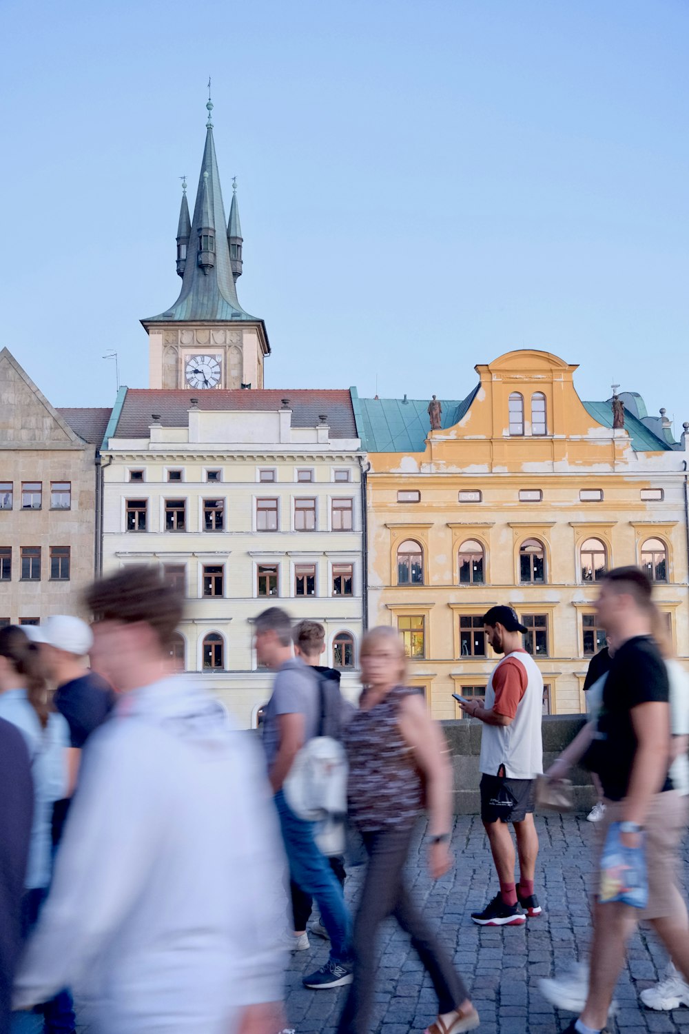 a group of people standing in front of a building with a clock tower