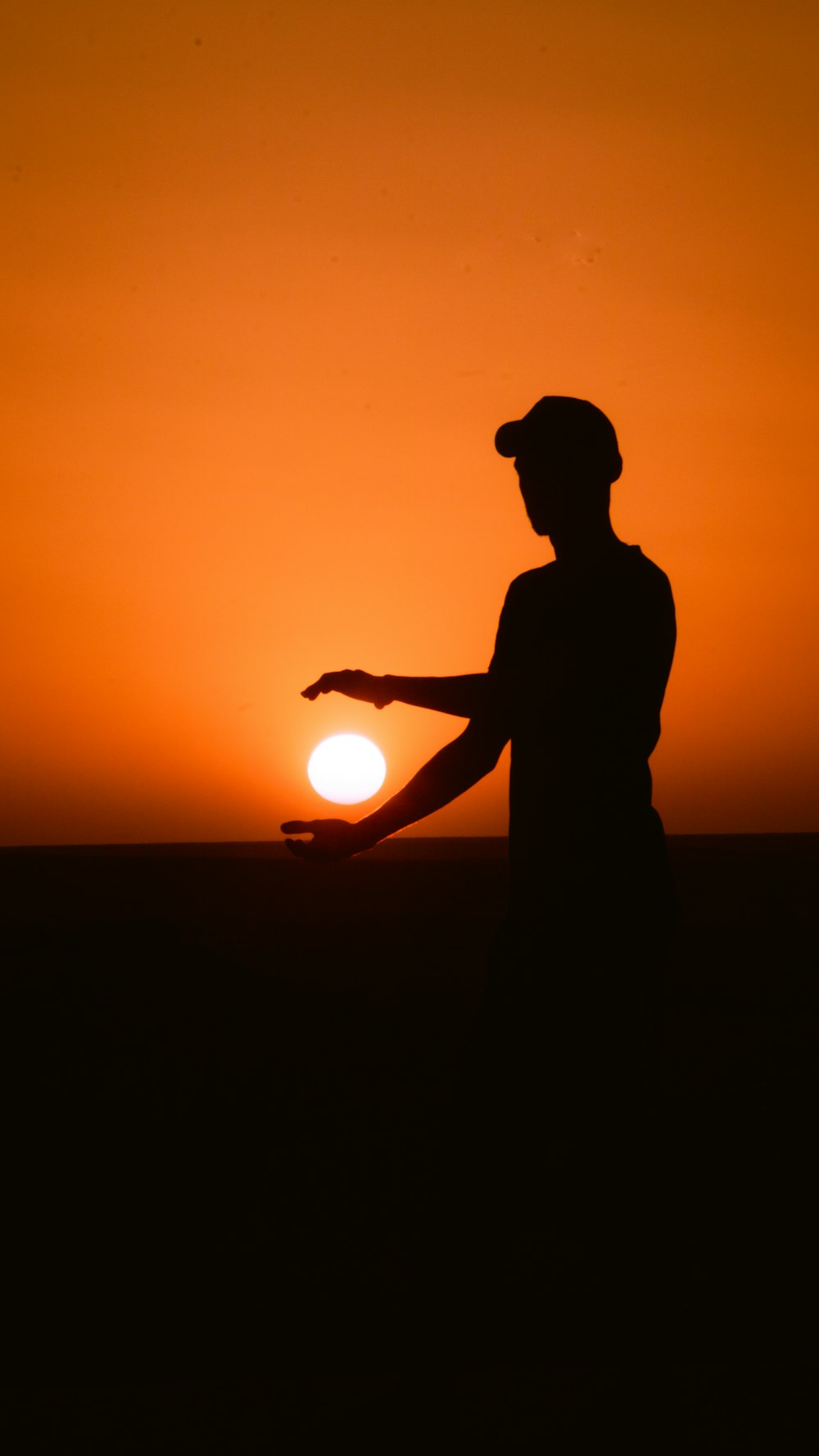 a silhouette of a person holding a light up to their face