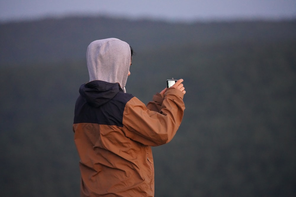 a person taking a picture of a mountain