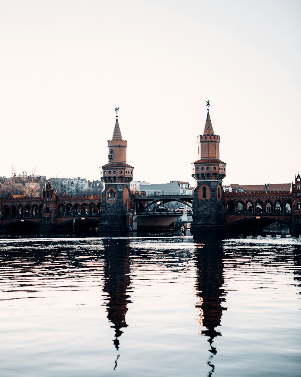 a bridge over a body of water with a building in the background