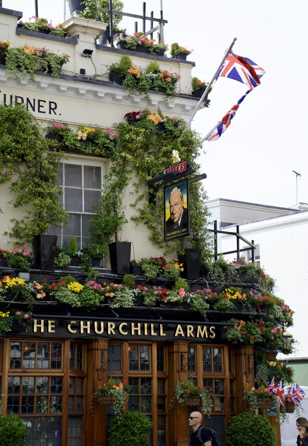 a building with a sign and flowers on it