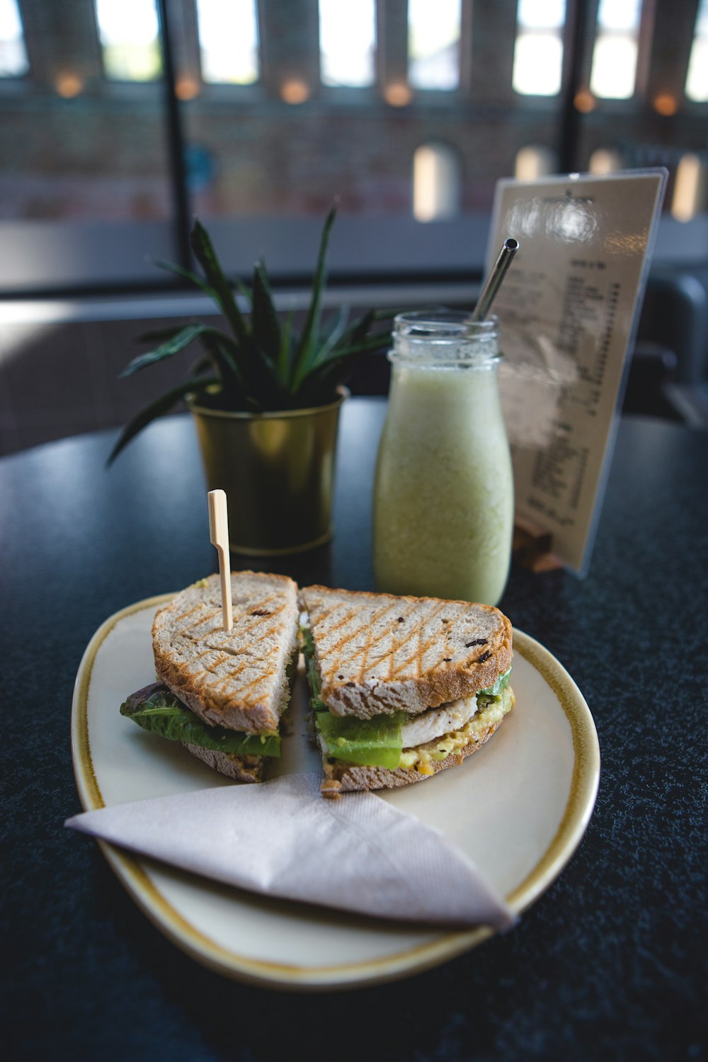a sandwich and a jar of spread on a table