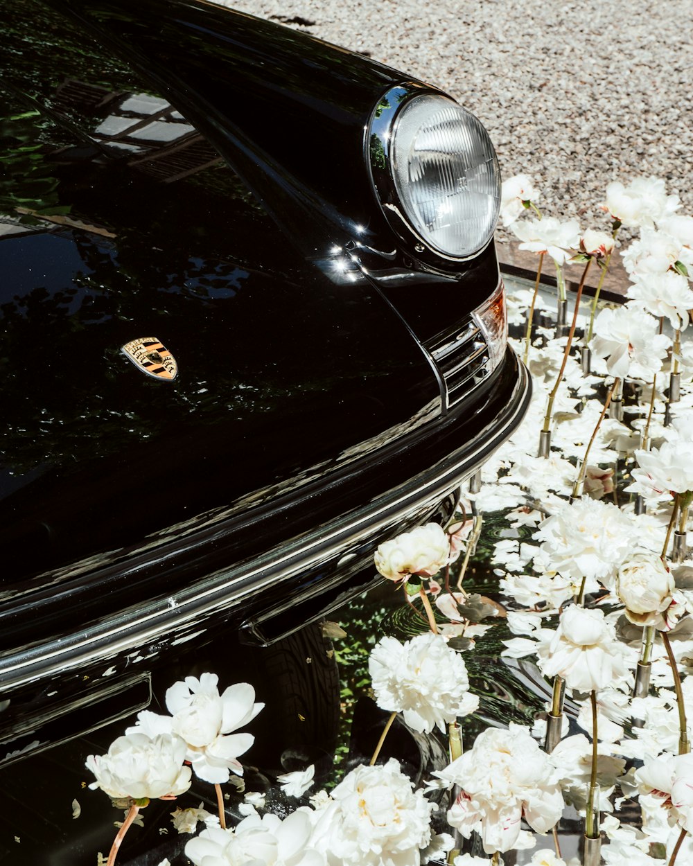 Un'auto nera parcheggiata in un sacco di fiori bianchi