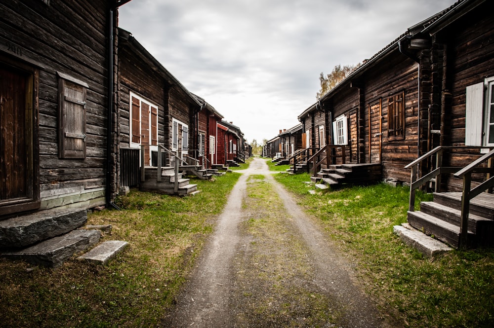 a dirt road between two wooden buildings