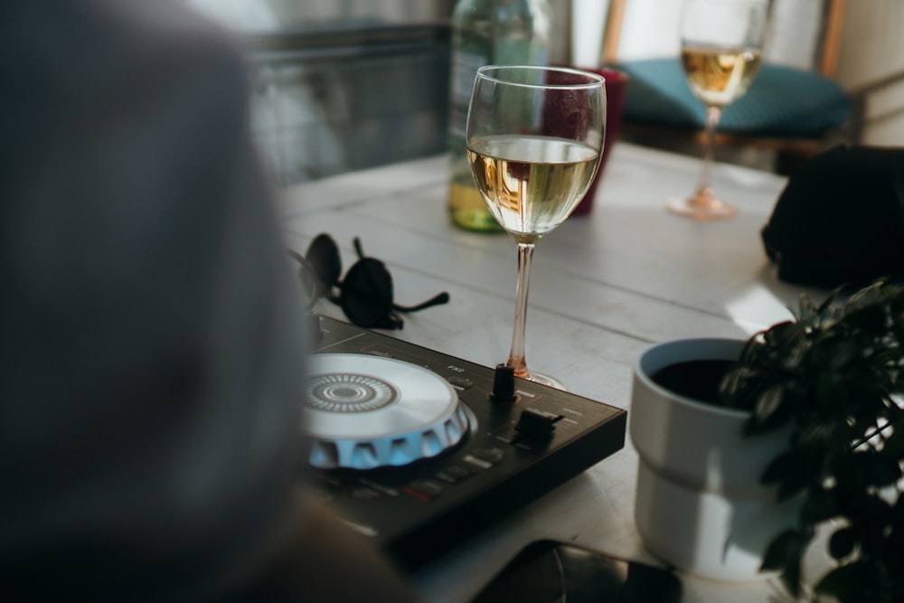 a glass of wine next to a cell phone and a glass of wine