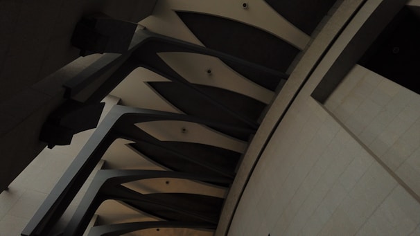 Architectural close-up of deep charcoal columns contrasted with warm grey textured walls.