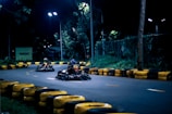 a group of people riding go karts on a road at night