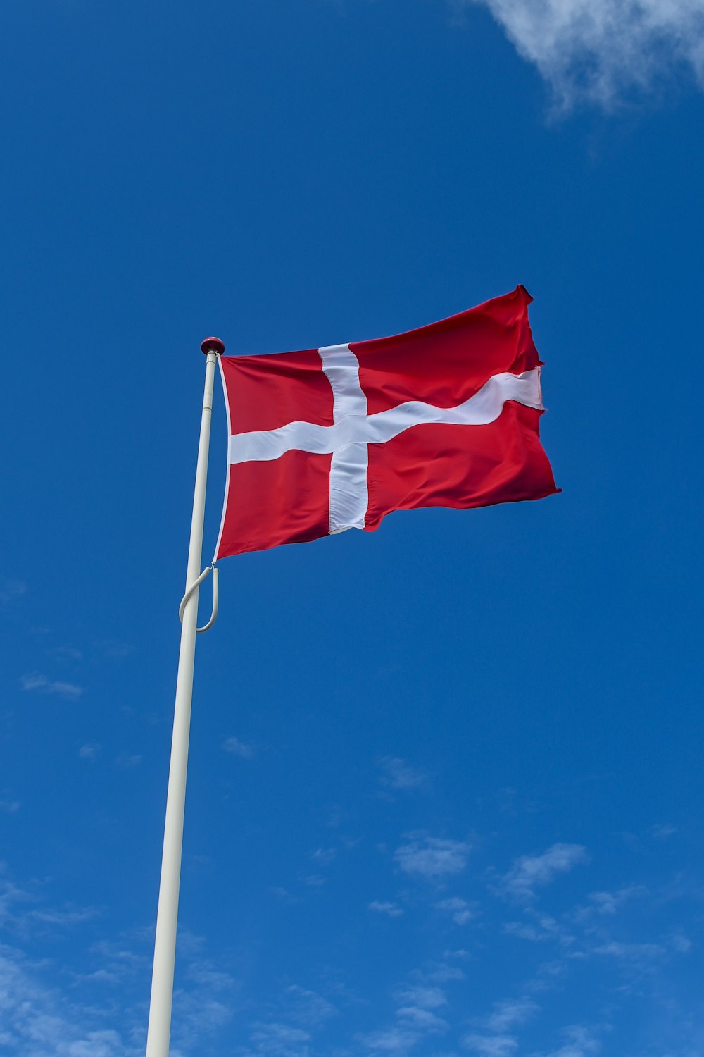 a red and white flag on a flagpole