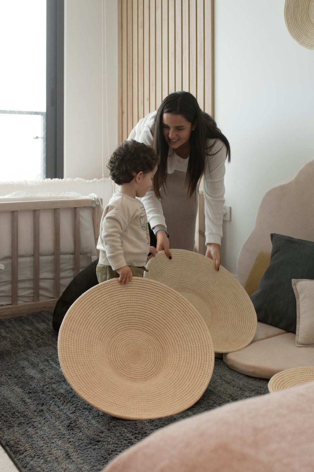 a person and a child in a room with a bed and a window