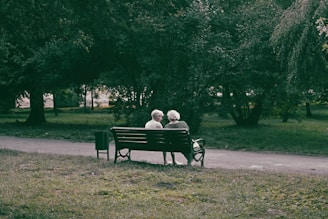 an elderly couple sitting on a bench