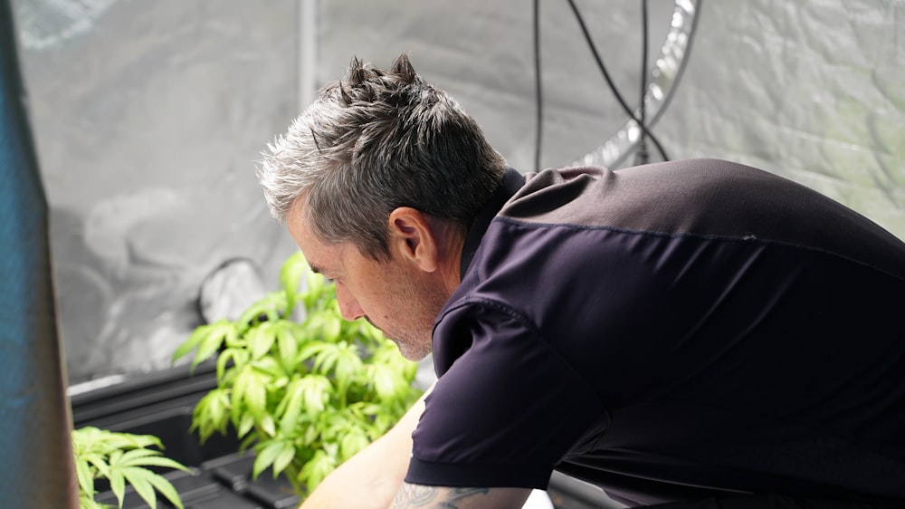 a man looking at a plant