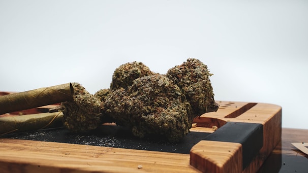 Close-up of cannabis buds and vape devices on a wooden table