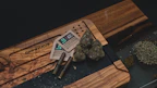Stylish cannabis accessories displayed on a wooden table with natural light