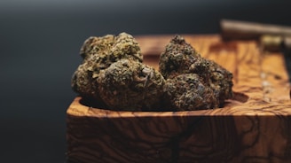 Close-up of vibrant cannabis buds glistening with trichomes on a wooden table.