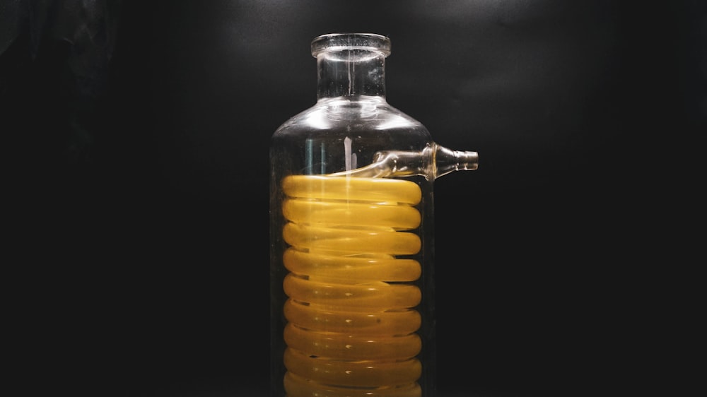 a glass bottle with a yellow liquid