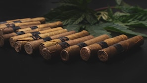 Artistic arrangement of Cuban cigars alongside a rustic wooden box and tobacco leaves.