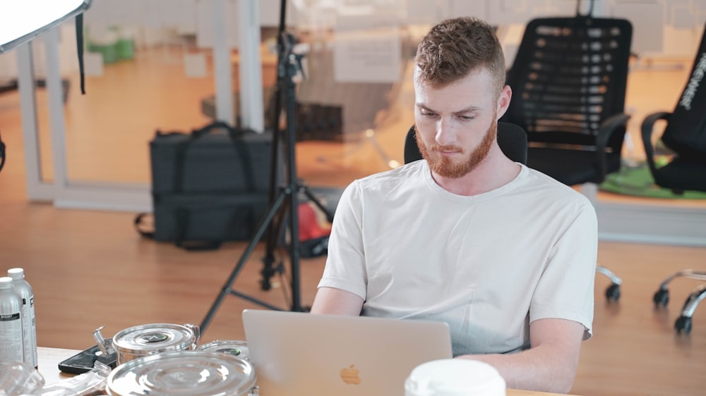 um homem sentado em uma mesa com um laptop