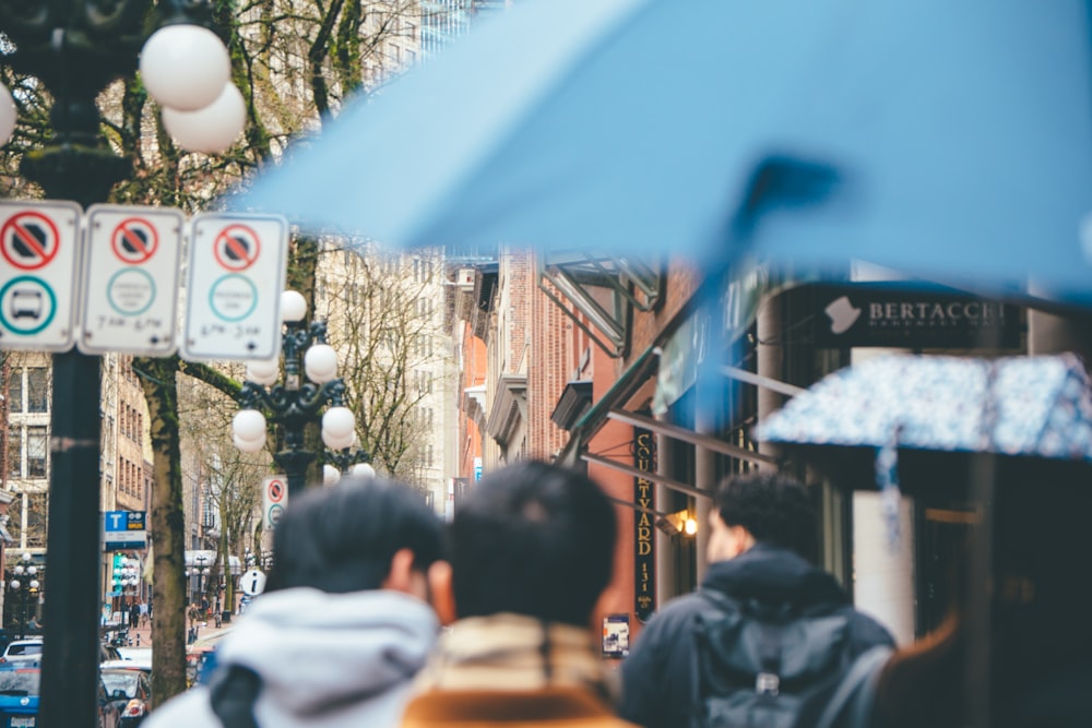 a group of people walk down a sidewalk