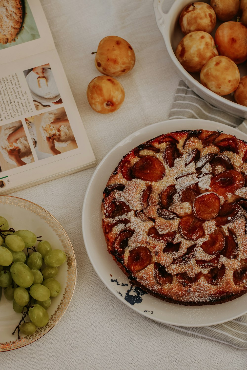 a pizza with grapes and a slice of pizza on a plate