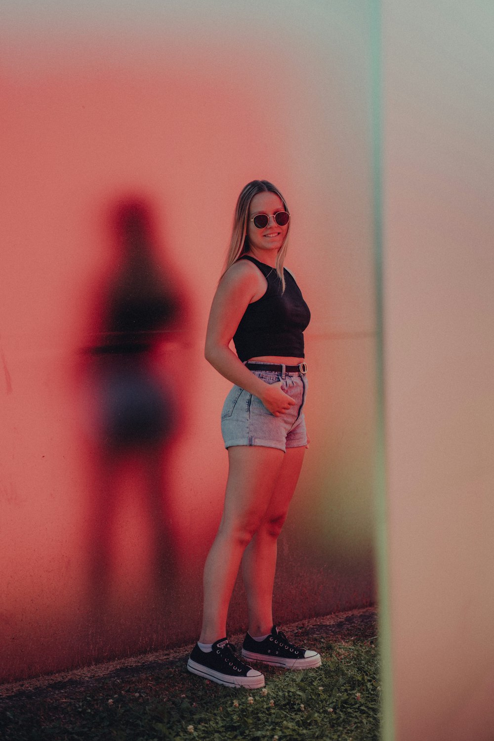 a woman posing in front of a wall