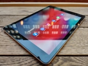 Social media icons floating above a tablet, representing diverse platforms.