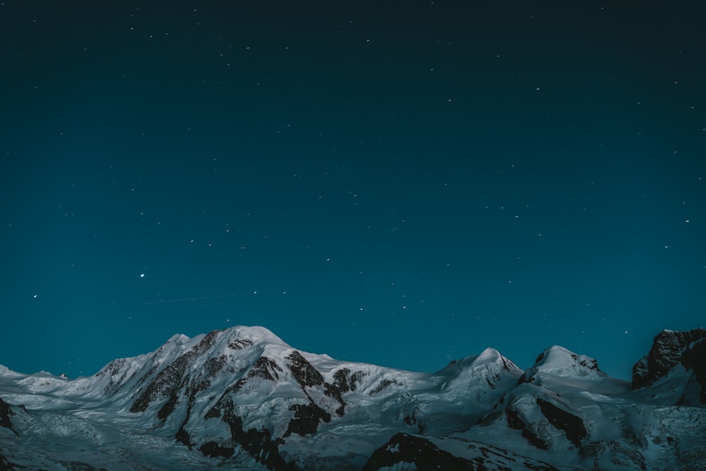 a snowy mountain with stars in the sky