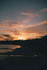 A serene sunset over the mangrove with silhouettes of people sharing stories.