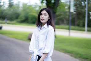A stylish woman wearing a casual t-shirt in a park.