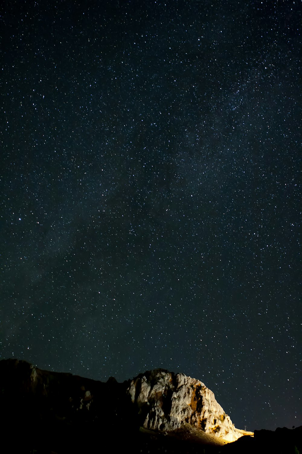 Una scogliera rocciosa sotto un cielo stellato