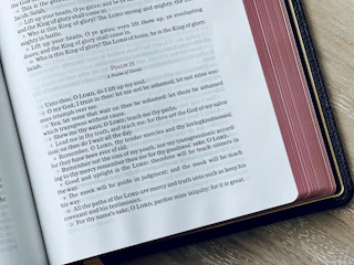 An open King James Bible resting on a rustic wooden table, soft light illuminating its pages.