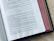 Close-up of hands holding an open Bible with soft golden light shining through.