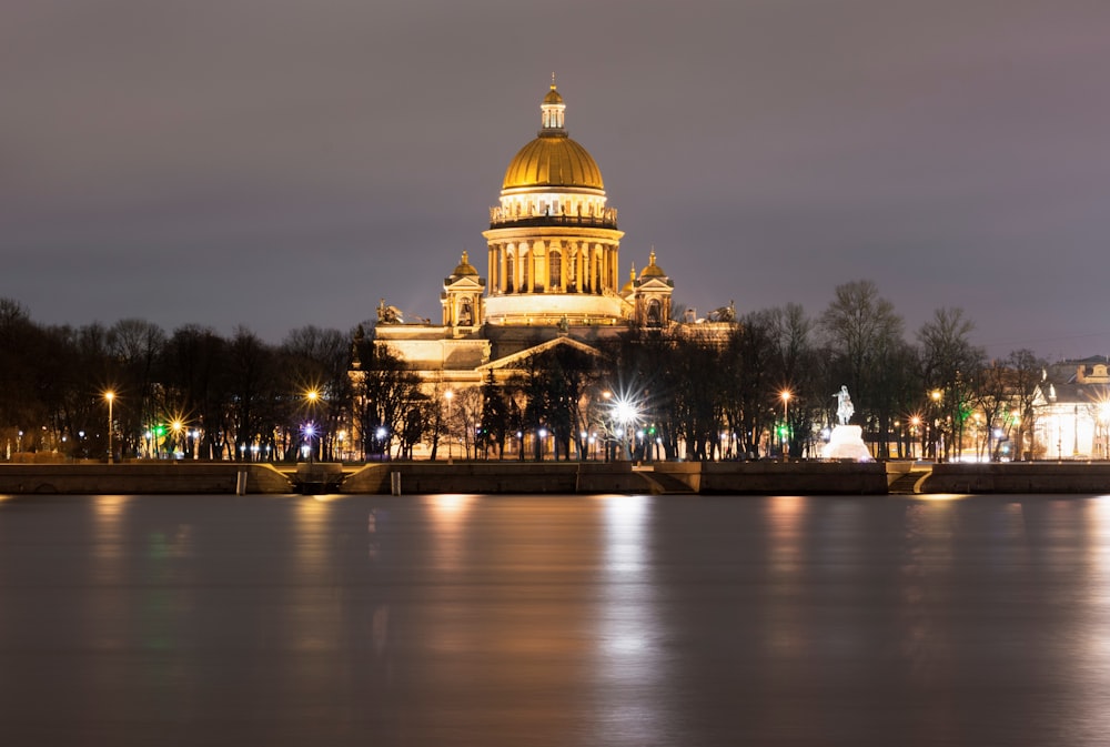 a large building with a gold domed roof and a body of water
