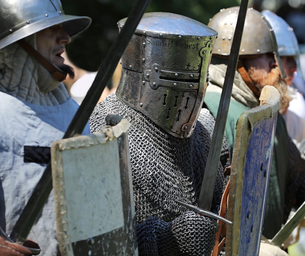 a group of people wearing helmets and holding a large metal object