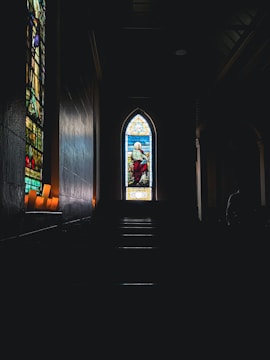 An old church with stained glass windows casting colorful light inside.