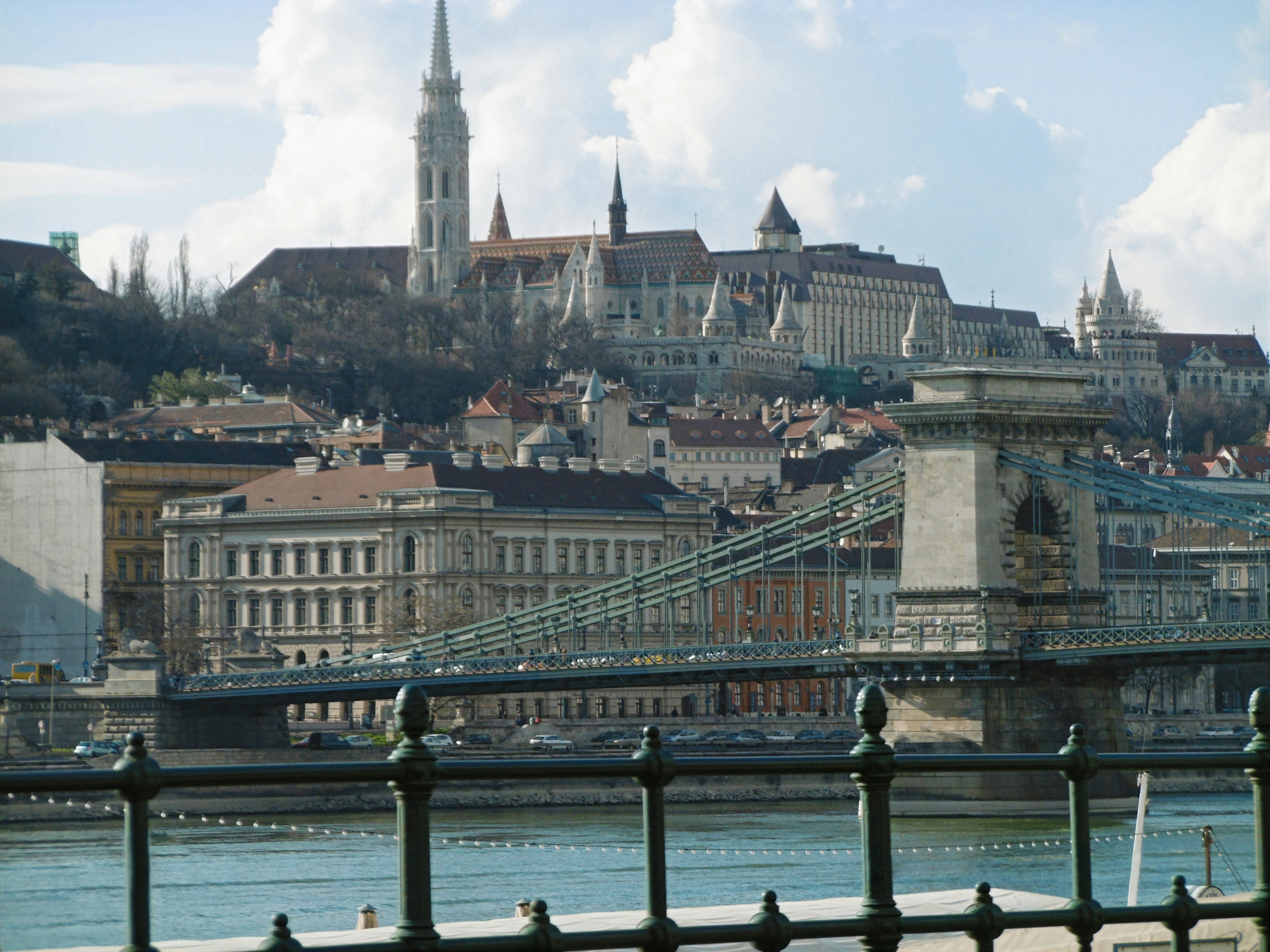 a bridge over water with buildings in the background