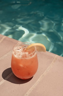 An insulated cooler bag filled with refreshing drinks beside a sparkling pool