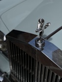 Close-up of the iconic Rolls Royce hood ornament gleaming under soft lighting
