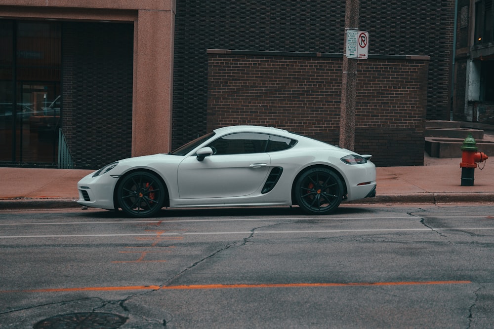 a white sports car parked on the side of a street