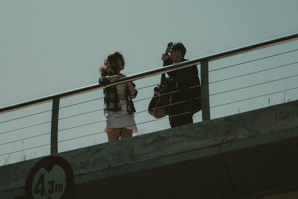 a man and woman standing on a bridge