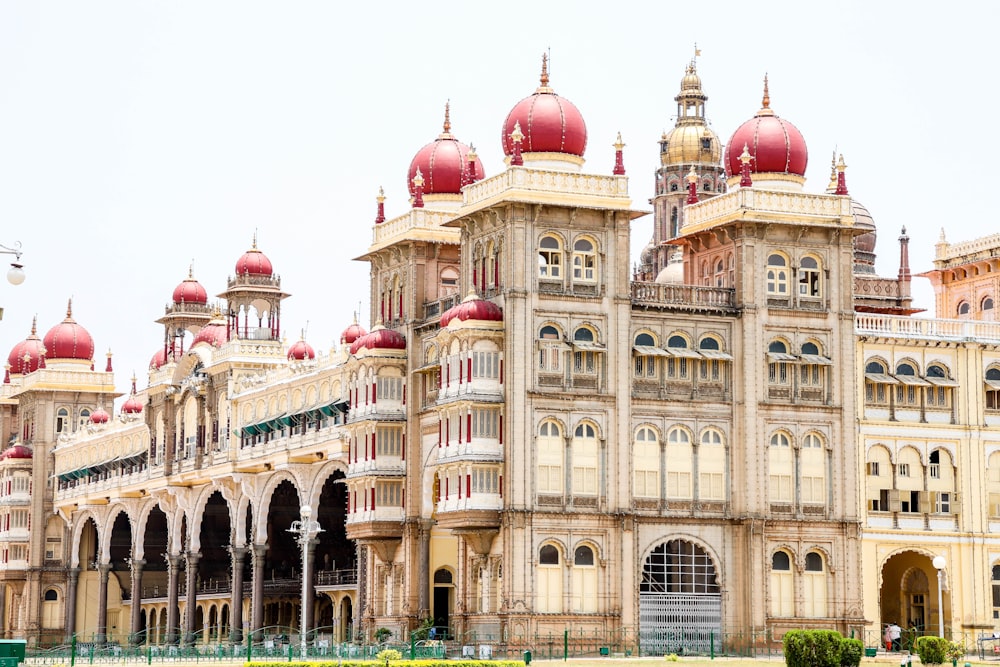 a large building with red domes with Mysore Palace in the background