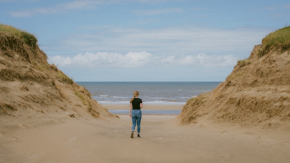 a person walking on a sandy beach