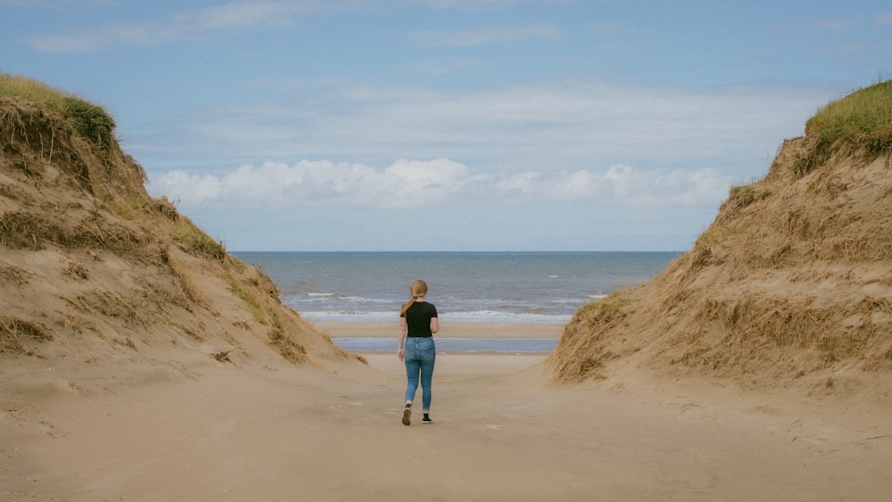 una persona caminando en una playa de arena